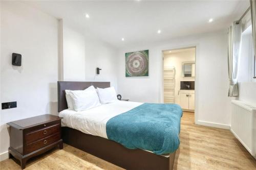a bedroom with a bed with a blue blanket at The Stables in Great Horkesley