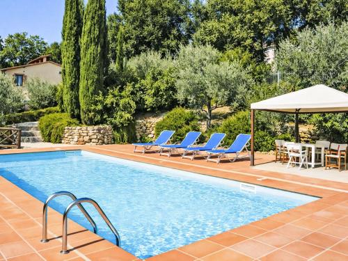 a swimming pool with chairs and a table and an umbrella at Villa Le More by Interhome in Penna in Teverina