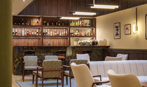 a bar with chairs and a white couch at Honest Budapest by chic&basic in Budapest