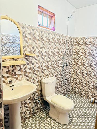 a bathroom with a toilet and a sink and a shower at Vinka Place Arugambay in Arugam Bay