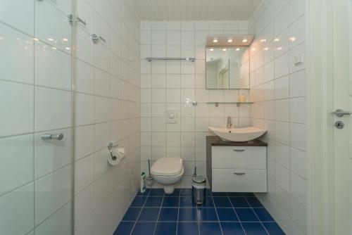 a white bathroom with a toilet and a sink at Rorbuene Svolvær Havn in Svolvær