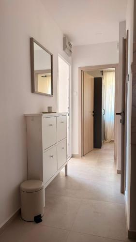 a bathroom with a white dresser and a mirror at Kazeta A-14,broj 28, Gajac in Skunca