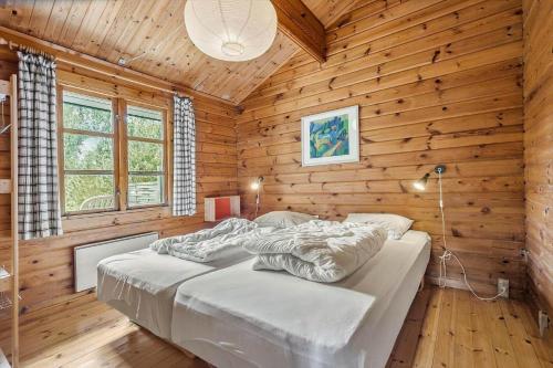 a bedroom with a bed in a wooden cabin at 84249-Knebel-Skraningen-13 in Knebel