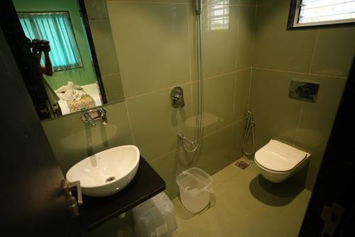 a bathroom with a shower and a sink and a toilet at Amorae Resort in Loni Khurd