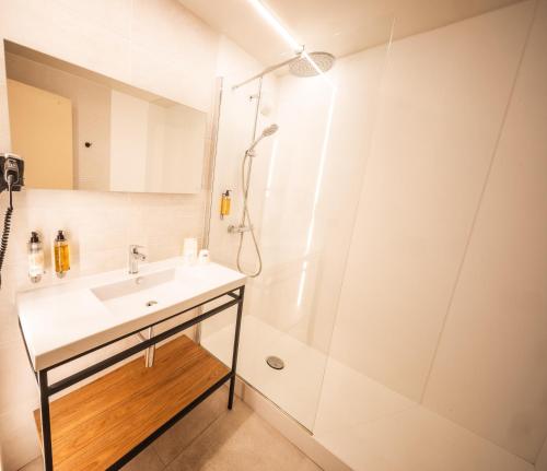 a bathroom with a sink and a shower at Hôtel Neste de Jade in Saint-Lary-Soulan