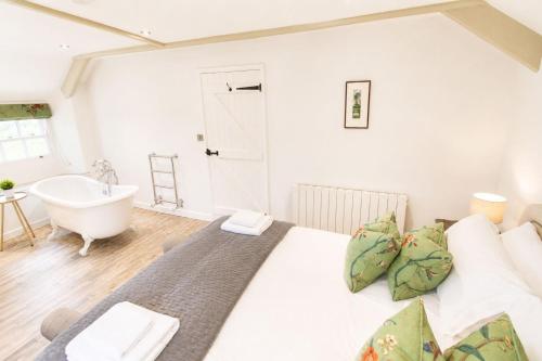 a bedroom with a large bed and a bath tub at Red Squirrel Cottage, Hutton luxurious cottage in a rural setting 10 minutes to Ullswater 15 minutes to Keswick in Penruddock