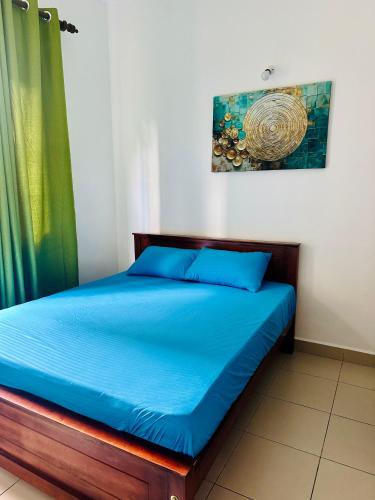 a bed with blue sheets in a room at Urban Nest Studio in Homagama