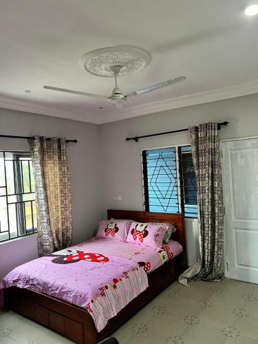 a bedroom with a bed with pink sheets and windows at Esthemers Royal Hotel in Brunkum