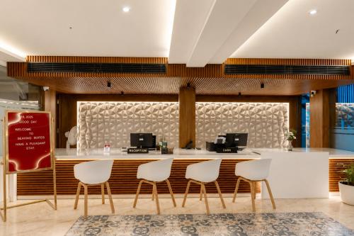 a restaurant with white chairs and a counter at Seaking Suites-MG Road in Cochin