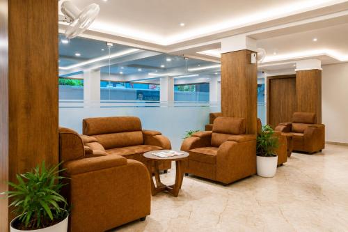 a waiting room with two chairs and a table at Seaking Suites-MG Road in Cochin