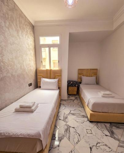 a room with two beds and a window at Bab Fes Medina Appartements Familiaux 2 Chambres - Parking & Navette in Fez