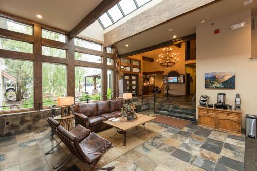 a large living room with leather furniture and windows at Meadow Lake Resort & Condos in Columbia Falls