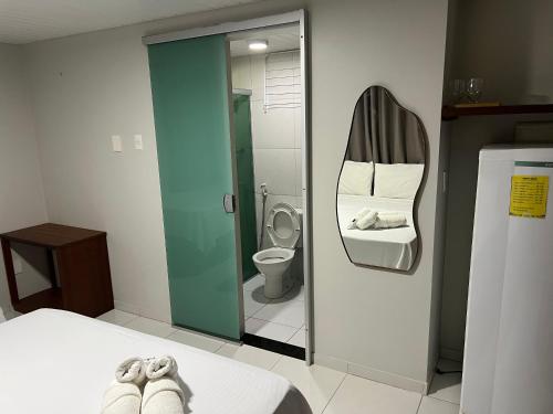a room with a bathroom with a toilet and a bed at Pousada Solar Maia Costa in Atins