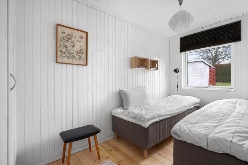 a bedroom with a bed and a chair and a window at 1671-Vejby-Blommevaenget-2 in Vejby