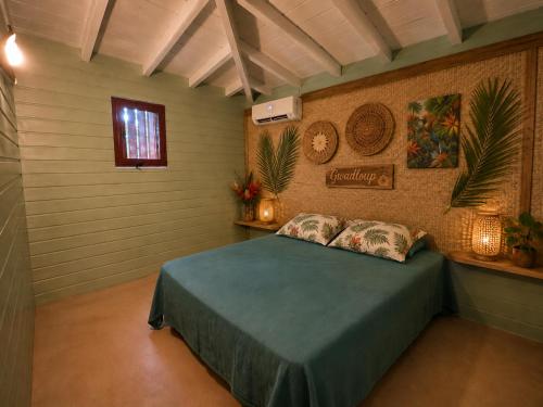 a bedroom with a blue bed in a room at La Baie des Villas in Deshaies