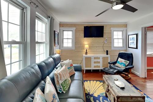 a living room with a leather couch and two chairs at CB Sunshine Cottage in Carolina Beach