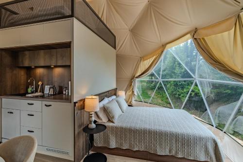 a bedroom in a tent with a bed and a window at Pilot Mountain Glamping Resort in Pinnacle
