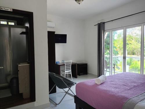 a bedroom with a bed and a table with a chair at HOKAB in Cenote Azul