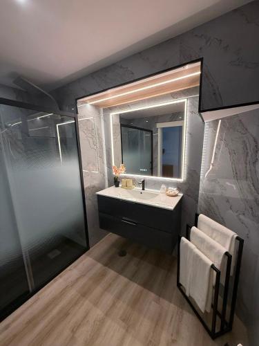a bathroom with a sink and a mirror at Hotel Apartamento Paraiso De Albufeira in Albufeira