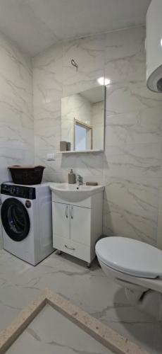 a white bathroom with a toilet and a sink at JMM Apartment in Kotor