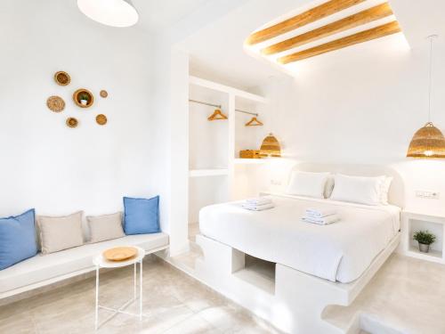 a white room with a bed and a couch at Thea Suites Naxos in Agios Prokopios