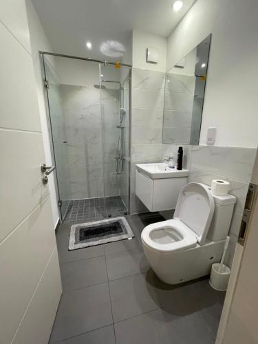a bathroom with a shower and a toilet and a sink at Executive Suites at The Lennox in Accra