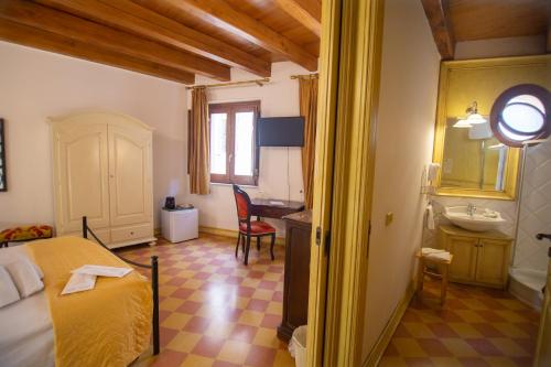 a bedroom with a bed and a bathroom with a sink at Atenea Luxury Suites - Atenea Collection in Agrigento