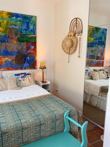 a bedroom with a bed and a painting on the wall at Le petit studio in Calonge