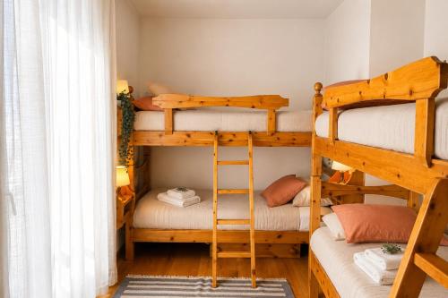 a room with two bunk beds and a ladder at Lhousing - Ideale per Famiglie e Gruppi in Asiago