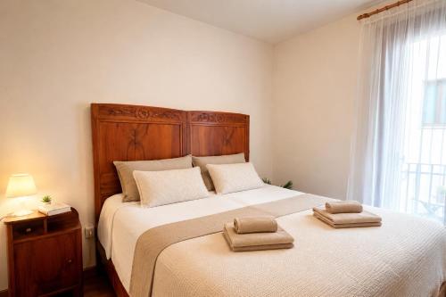 a bedroom with a large bed with two towels on it at Lhousing - Ideale per Famiglie e Gruppi in Asiago