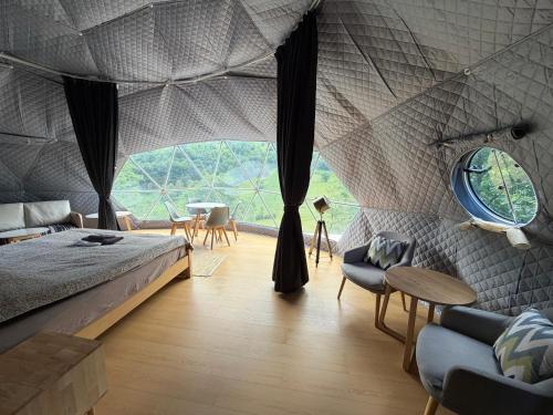 a bedroom with a tent with a bed and a table at Ursa Camp Mountain Glamping in Gornje Lipovo