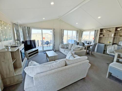 a living room with white couches and a tv at The Retreat 22 - Ukc9564 in Ingoldmells