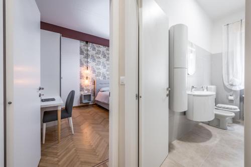 a bathroom with a toilet and a sink and a desk at Casa Amelia - Elegant Suite [parcheggio gratuito] in Parma