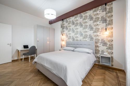 a bedroom with a large white bed and a desk at Casa Amelia - Elegant Suite [parcheggio gratuito] in Parma