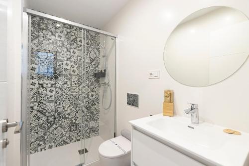 a bathroom with a shower and a sink and a mirror at NerjaPlus Terraza de Ladera Apartamento V11 in Nerja