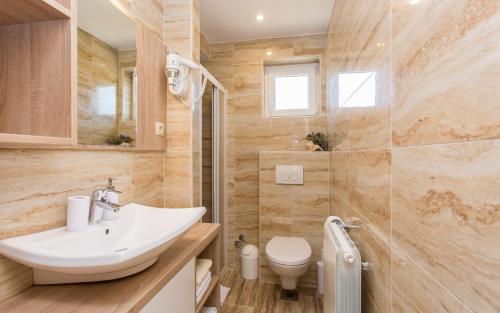 a bathroom with a sink and a toilet at Apartments Polonijo in Baška