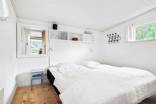 a white bedroom with a bed and a blue stool at 30016-Beder-Solsortevaenget-19 in Beder