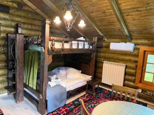 a bedroom with a bunk bed in a log cabin at Cabana Vadim in Turda