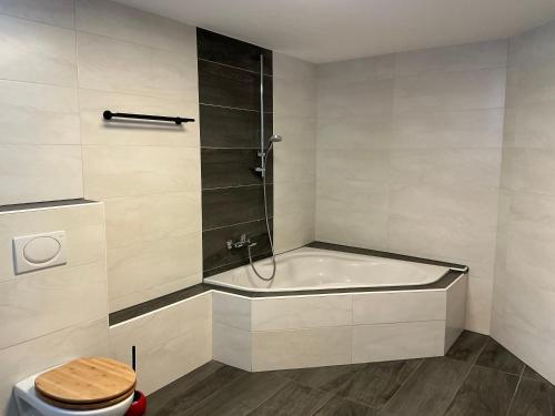a bathroom with a bath tub and a toilet at Ferienwohnung Sevim in Lermoos