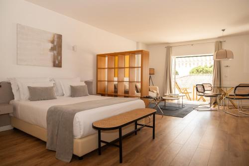 a bedroom with a large bed and a table and chairs at Vila Bicuda Resort in Cascais