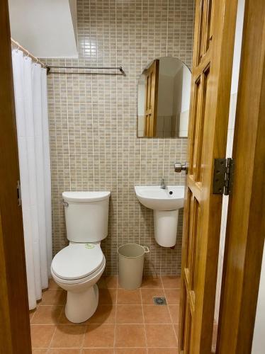 a bathroom with a toilet and a sink at The Uptown deluXE Studio #5 in Balulang