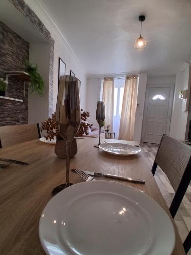 a dining room table with a white plate on it at Maison SYD saint-Junien in Saint-Junien
