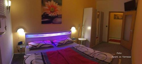 um quarto com uma cama com luzes roxas em FeWo Shervin em Nümbrecht