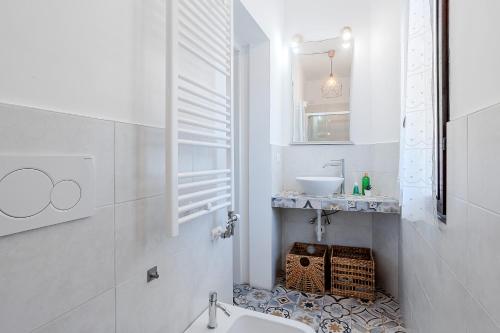 a white bathroom with a sink and a mirror at Le Finestre Sul Borgo 1 in Parma