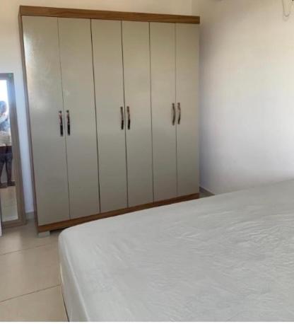 a bedroom with white cabinets and a bed at Day aconchego in Aracaju