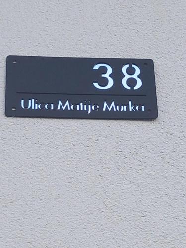 a sign on the side of a wall with the number at Apartment Zorec in Maribor