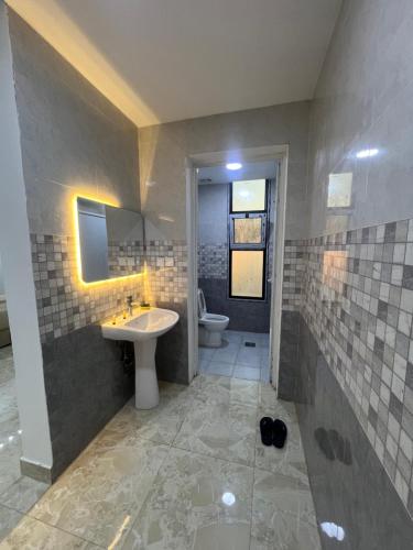 a bathroom with a sink and a toilet at شقق الشموخ in Dammam