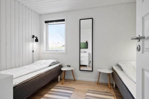 a bedroom with two beds and a mirror at 30392-Odder-Delfinvej-5 in Odder