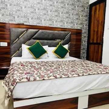 a bedroom with a large bed with green pillows at Hotel Lucifer by Evening Star in Bathinda