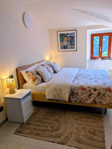 a bedroom with a bed and a table and a window at All About You Montefiore in Casola in Lunigiana